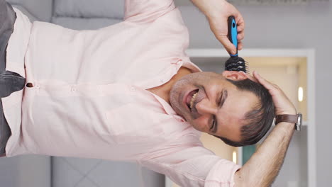 Vertical-video-of-Man-combing-his-hair.
